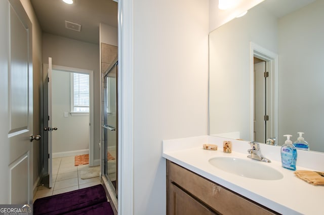 bathroom with vanity, a shower with shower door, and tile patterned floors