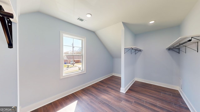spacious closet with dark wood finished floors, visible vents, and lofted ceiling
