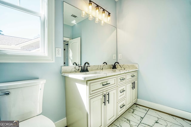 bathroom featuring visible vents, baseboards, toilet, double vanity, and marble finish floor