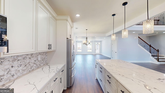 kitchen featuring dark wood finished floors, stainless steel fridge with ice dispenser, white cabinets, tasteful backsplash, and a chandelier