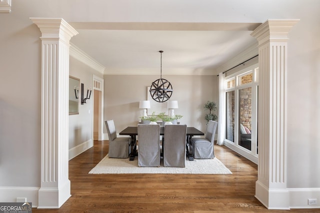 dining room featuring crown molding, an inviting chandelier, ornate columns, and dark hardwood / wood-style floors