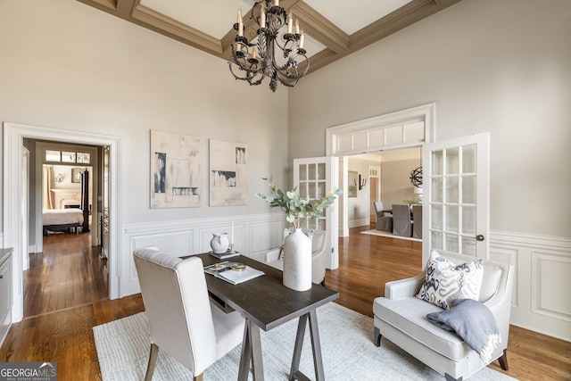 office space with coffered ceiling, an inviting chandelier, dark wood-type flooring, a high ceiling, and beam ceiling