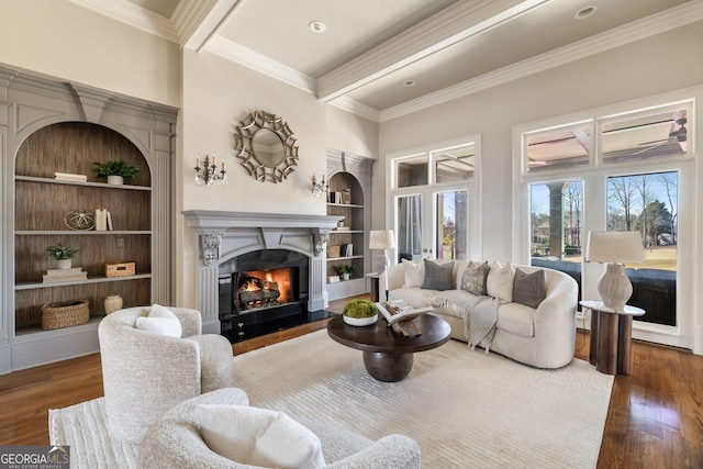 living room with beamed ceiling, built in shelves, dark hardwood / wood-style flooring, and ornamental molding