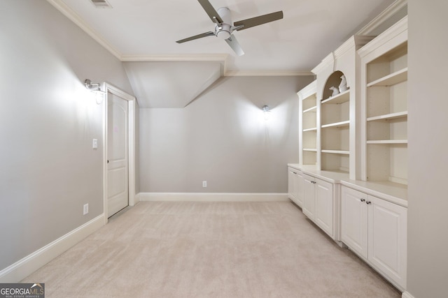 empty room with ornamental molding, ceiling fan, vaulted ceiling, and light colored carpet