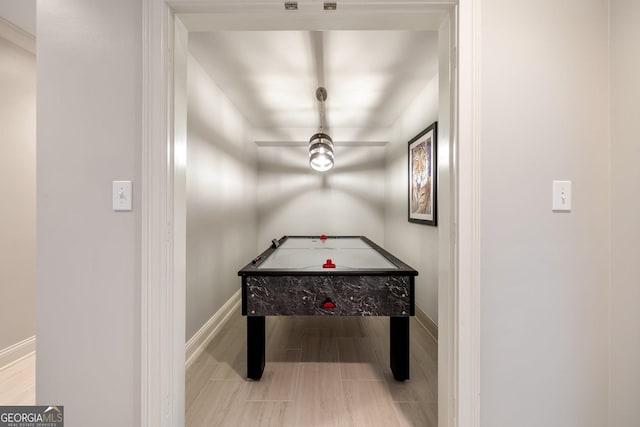 playroom with ceiling fan and light hardwood / wood-style flooring