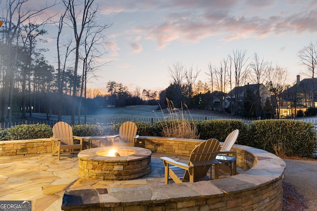 patio terrace at dusk featuring a fire pit