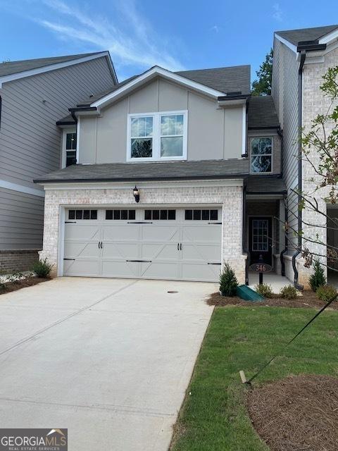 view of property with a garage and a front lawn