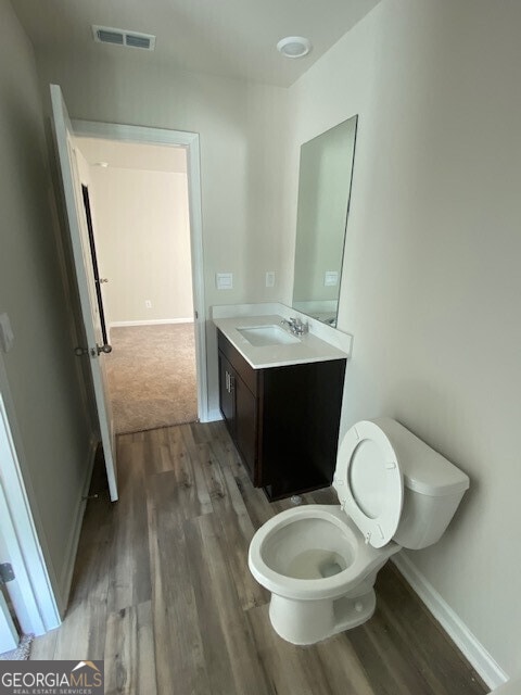 bathroom featuring vanity, hardwood / wood-style flooring, and toilet