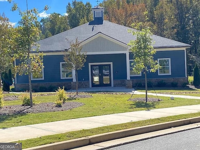 view of front of property with french doors and a front lawn