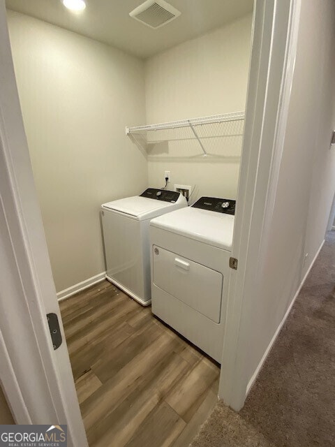 laundry room with washing machine and dryer and dark hardwood / wood-style flooring