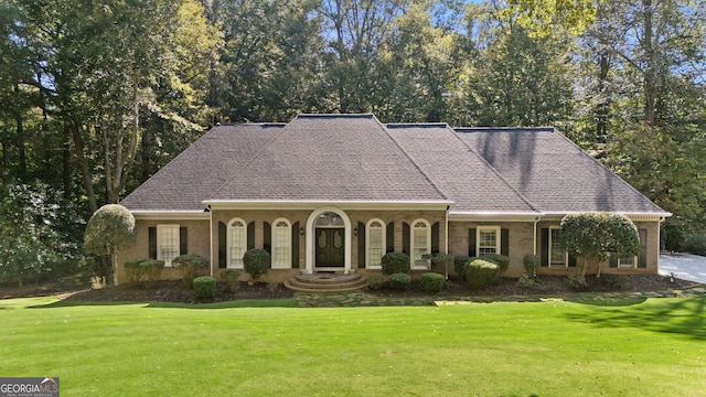 view of front of house featuring a front lawn and brick siding