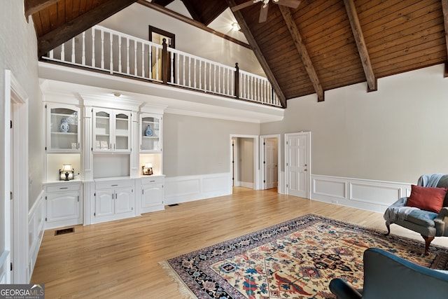 living area featuring visible vents, wood ceiling, a ceiling fan, light wood finished floors, and beamed ceiling