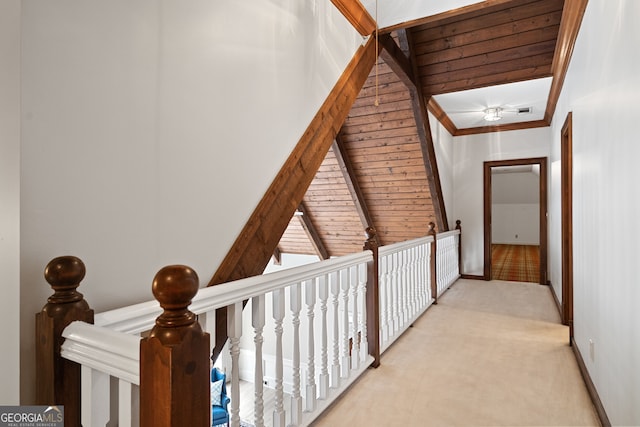 hallway featuring baseboards, crown molding, and light colored carpet