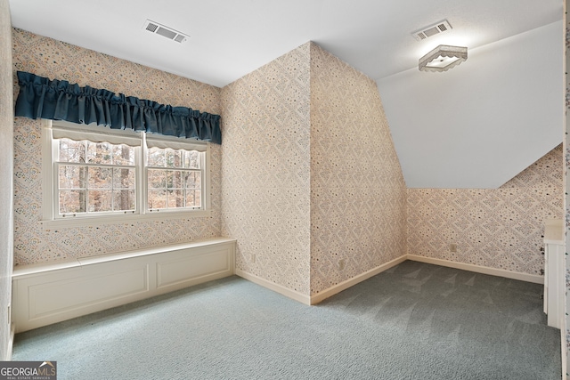 additional living space with visible vents, light carpet, and wallpapered walls