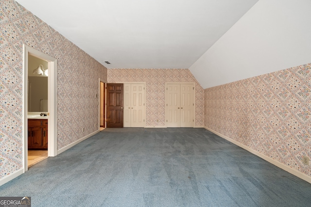 additional living space with wallpapered walls, visible vents, and carpet flooring