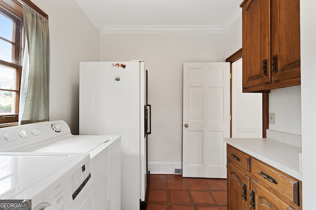 laundry area featuring cabinet space, ornamental molding, separate washer and dryer, and dark tile patterned flooring