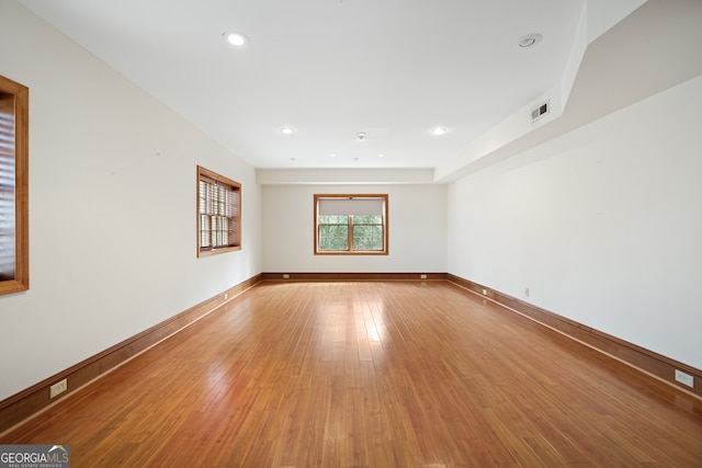 spare room featuring light wood-type flooring, visible vents, baseboards, and recessed lighting