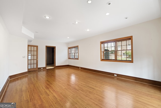 empty room with baseboards, wood finished floors, and recessed lighting