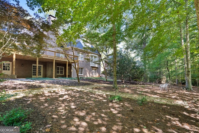 view of yard featuring a wooden deck and french doors