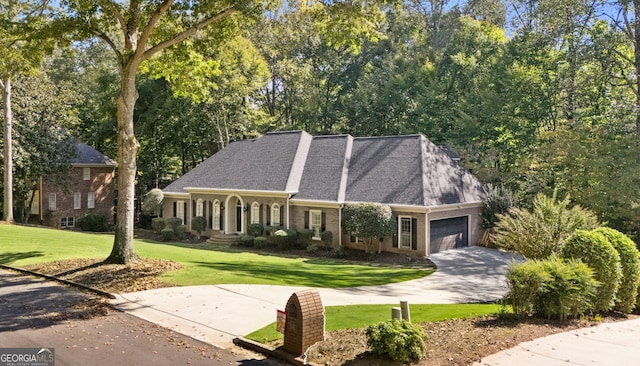 view of front of property with driveway, a shingled roof, an attached garage, a front yard, and brick siding