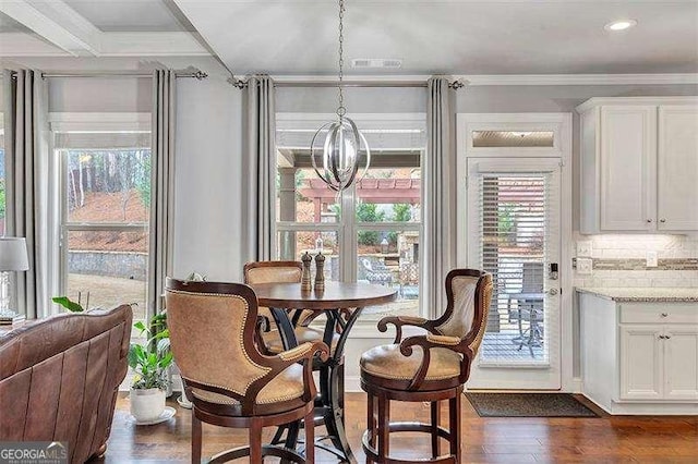 dining area with crown molding and dark wood-type flooring