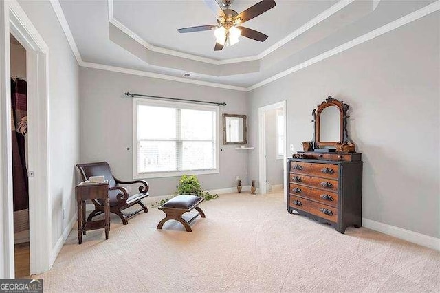 sitting room featuring ornamental molding, light colored carpet, a raised ceiling, and ceiling fan