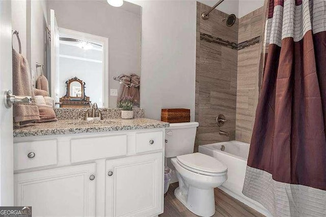 full bathroom with hardwood / wood-style flooring, shower / bath combo, vanity, and toilet