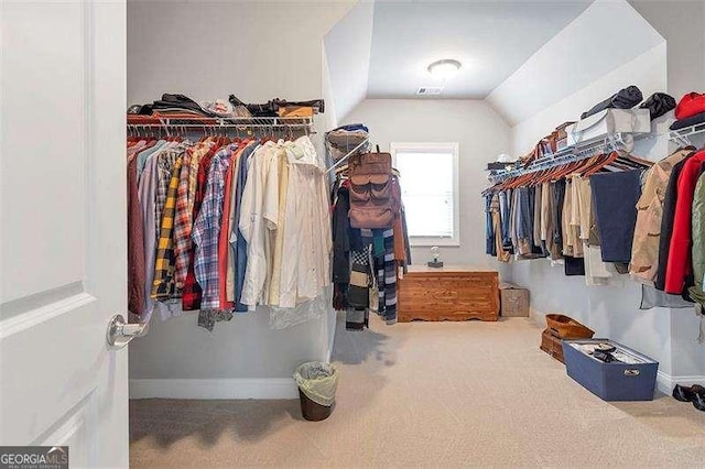 walk in closet with lofted ceiling and carpet