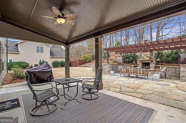 deck featuring a patio, ceiling fan, and an outdoor stone fireplace