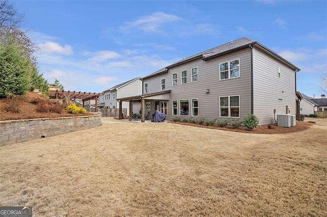 back of property with a yard, central AC, and a pergola