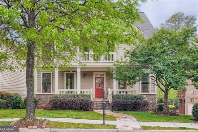 view of property hidden behind natural elements featuring a front lawn and a porch