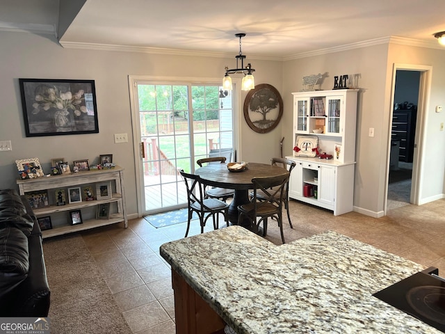 dining space with ornamental molding, an inviting chandelier, baseboards, and light tile patterned floors