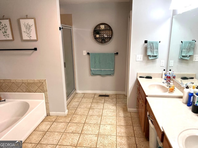 bathroom featuring a stall shower, a garden tub, vanity, and baseboards