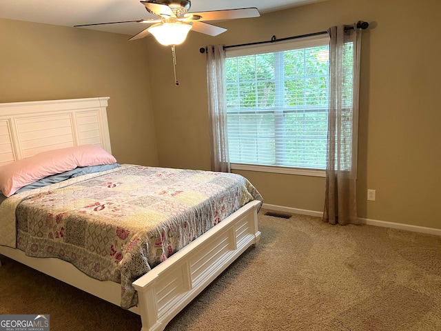 carpeted bedroom with ceiling fan, visible vents, and baseboards