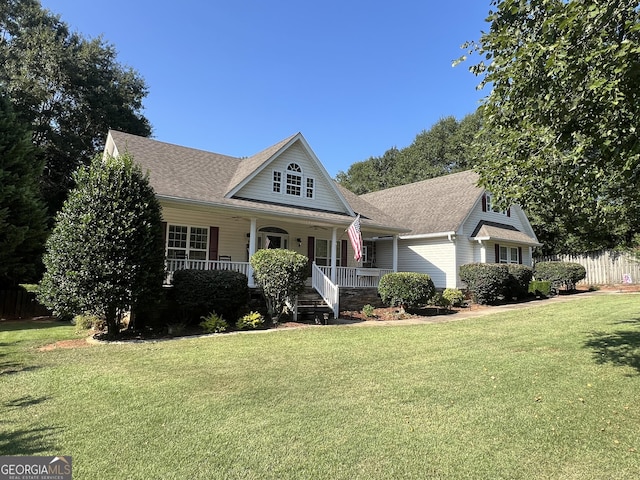 view of front of home with a porch, a front yard, and fence