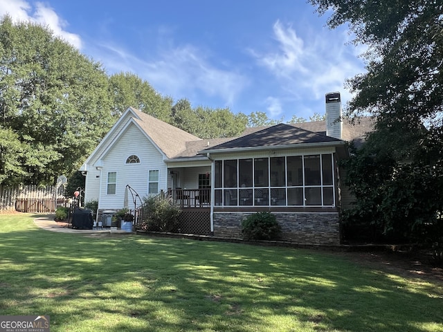 back of house featuring a lawn, a patio, a sunroom, a chimney, and fence