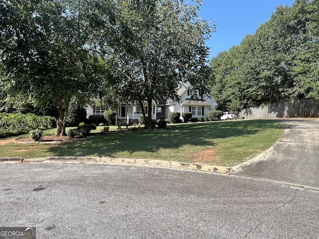 obstructed view of property featuring a front yard and fence