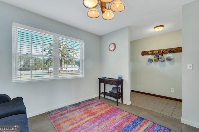 interior space featuring baseboards, tile patterned floors, and a notable chandelier