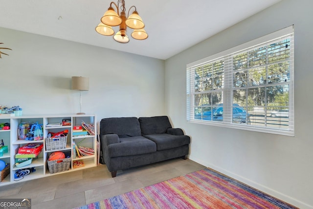 living area featuring tile patterned flooring, a chandelier, and baseboards