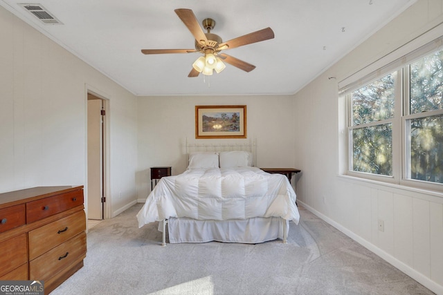 bedroom featuring light carpet, baseboards, visible vents, ceiling fan, and crown molding