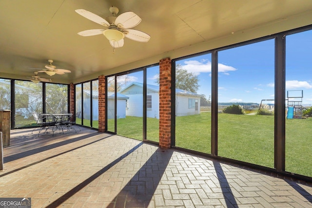 unfurnished sunroom with a ceiling fan