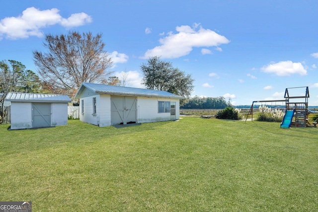 view of yard featuring an outbuilding, a playground, and a shed