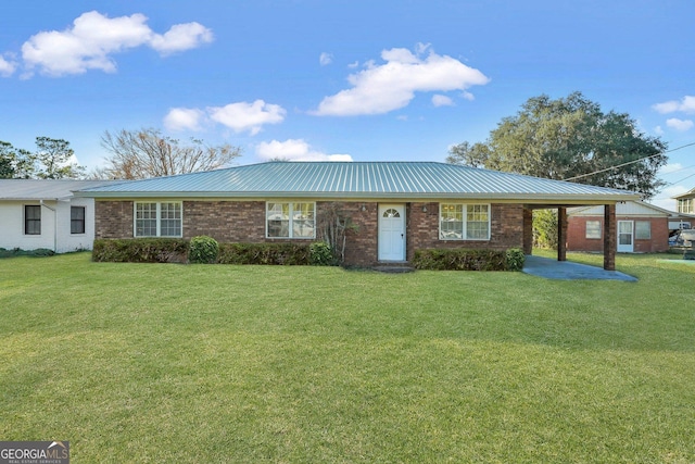 ranch-style home featuring a carport, brick siding, metal roof, and a front lawn