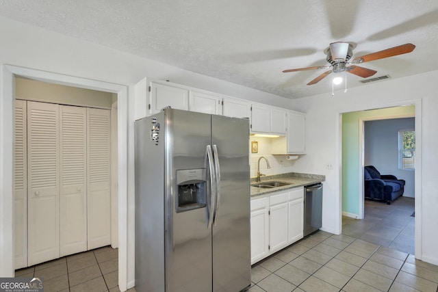 kitchen with appliances with stainless steel finishes, white cabinets, visible vents, and a sink