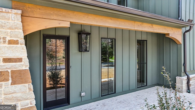 entrance to property featuring stone siding and board and batten siding