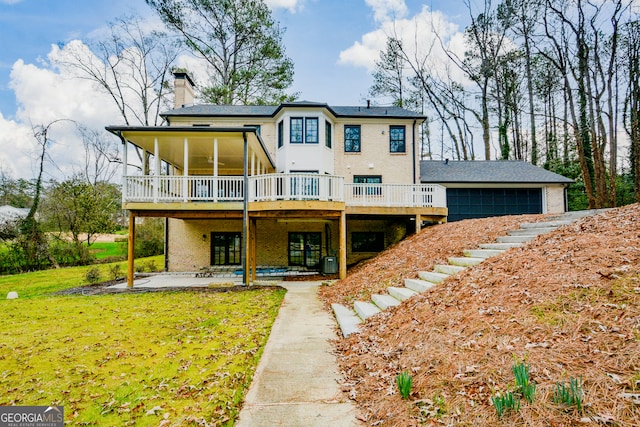 rear view of property with a lawn, a chimney, a wooden deck, a patio area, and central AC