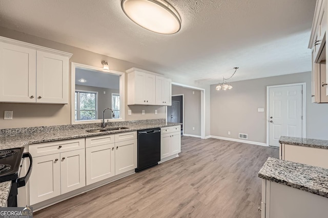 kitchen with black appliances, visible vents, white cabinetry, and a sink