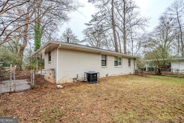 rear view of house featuring a yard and central AC unit