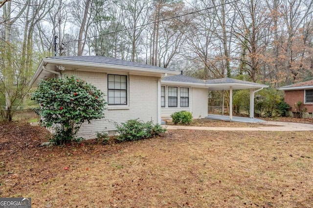 view of front of property with a front lawn and a carport