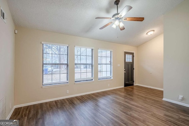 foyer featuring ceiling fan, lofted ceiling, a textured ceiling, and dark hardwood / wood-style flooring